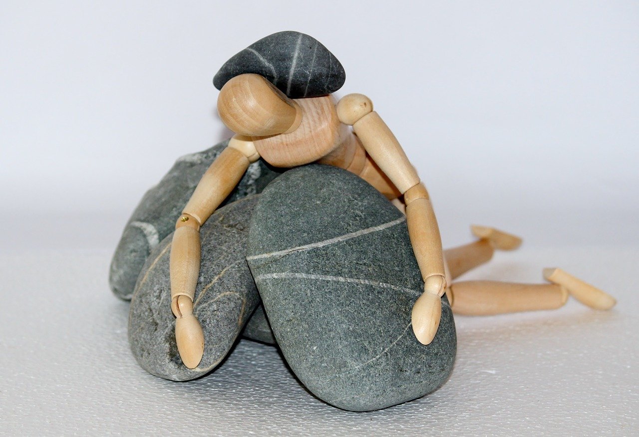Икеевский деревянный человечек на шарнирах упал на камни